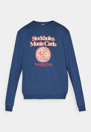 Námornícky modrý sweatshirt s okrúhlym výstrihom, dlhými rukávmi a grafickou potlačou globusu s názvom 'Stockholm Monte Carlo Tennis Club'.