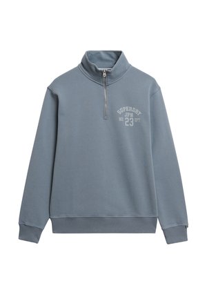 Felpa leggera azzurra a mezze zip realizzata in tessuto morbido, con orlo e polsini a coste. Grafica frontale notevole: "SUPERDRY JPN 23 DPT."