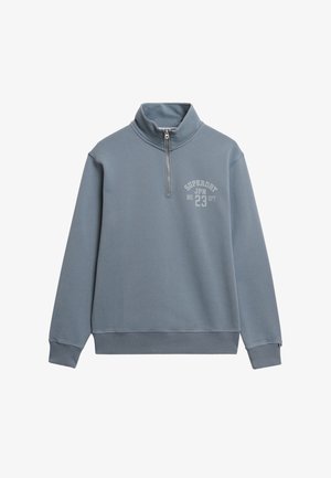 Felpa leggera azzurra a mezze zip realizzata in tessuto morbido, con orlo e polsini a coste. Grafica frontale notevole: "SUPERDRY JPN 23 DPT."