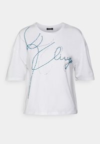 Camiseta de algodón blanca con mangas cortas y un corte holgado. Presenta adornos de strass en azul y plateado en un diseño fluido.