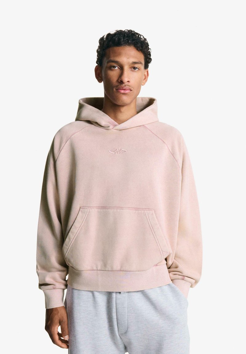 Rózsaszín, bolyhos kapucnis pulóver elülső zsebbel, raglán ujjakkal és húzózsinóros kapucnival. Puha tapintású szövet, mellkason hímzett logóval.