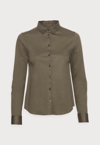 Camisa de manga larga color verde oliva con cuello puntiagudo, cierre frontal de botones y acentos de botones oscuros. Tela de algodón suave con puños doblados.