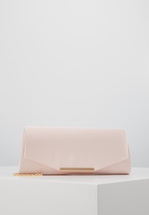 Ljusrosa satin clutchväska med guldkedja och guld rektangulär spänne som vilar på en vit yta mot en ljusgrå bakgrund.