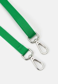 Due cordini in tessuto verde con ganci a moschettone girevoli in metallo argentato su uno sfondo bianco.