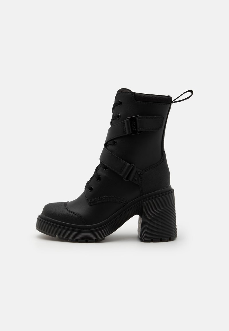 Bottines noires à talon épais, en matériau synthétique lisse, avec un laçage à l'avant et des sangles réglables au niveau du milieu du pied.