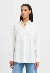 Camicia bianca a maniche lunghe realizzata in cotone, con colletto classico e vestibilità comoda. Design semplice senza motivi.