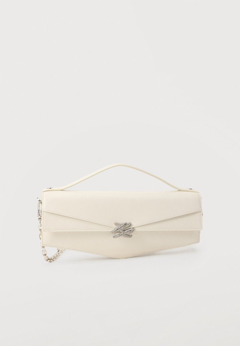 Κρεμ χρώματος τσάντα φάκελος από δέρμα με πάνω λαβή, ασημένια αλυσίδα ιμάντα και ασημένιο διακοσμητικό κούμπωμα με λογότυπο στο μπροστινό καπάκι.