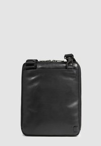 Borsa in pelle nera con texture liscia, forma quadrata, chiusura a doppia cerniera e spallacci regolabili. Presenta un design minimalista e senza loghi visibili.