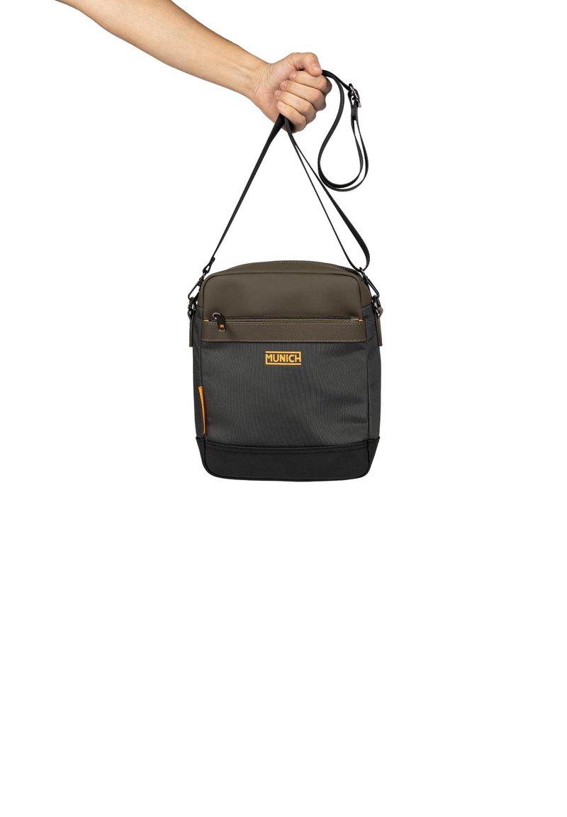 Bolso bandolera negro y gris con una textura suave, que presenta un bolsillo frontal con cremallera, correa ajustable y logotipo de acento naranja.