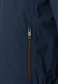 Mørkeblå vandtæt jakke med en sidelukning og orange detaljer, glat tekstur og minimalistisk design.