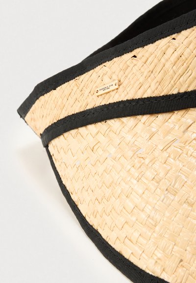 Καπέλο με φαρδύ γείσο από ψάθα με φυσική υφή ύφανσης, διακοσμημένο με μαύρη κορδέλα γύρω από τη βάση και μια μικρή μεταλλική ετικέτα με λογότυπο.