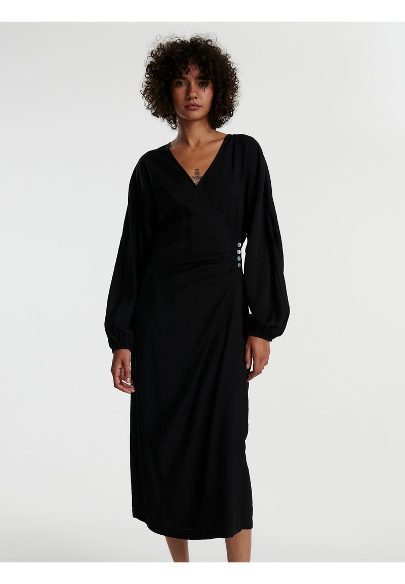 Schwarzes Wickelkleid aus weichem Stoff, mit langen Puffärmeln, einem tiefen V-Ausschnitt und dekorativen Knöpfen an der Seite. Einfaches und fließendes Design.