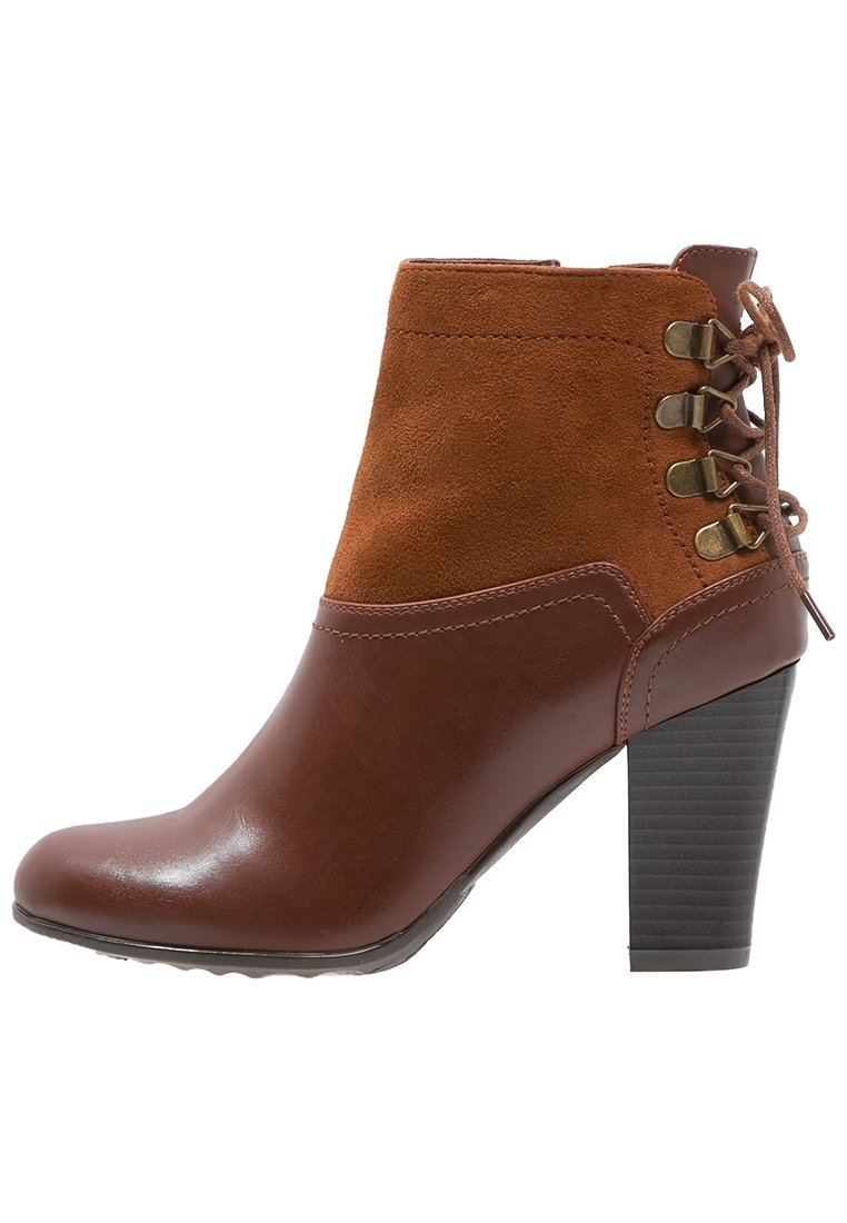 Bottine marron avec un corps en cuir et un dessus en daim, présentant un laçage sur les côtés, un talon bloc haut, et une finition lisse et brillante.