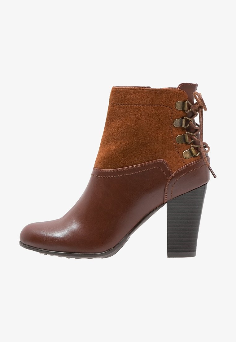 Bottine marron avec un corps en cuir et un dessus en daim, présentant un laçage sur les côtés, un talon bloc haut, et une finition lisse et brillante.