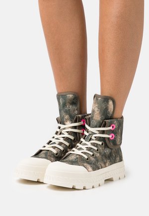 Zapatillas altas de lona con un diseño de patrones en verde y marrón, suela de goma blanca y ojales rosa brillante con cordones blancos.