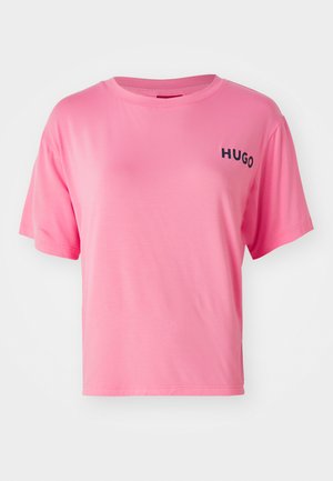Rosa bomullströja med en avslappnad passform, rund halsringning och korta ärmar. Har texten "HUGO" i svart på vänster bröst.
