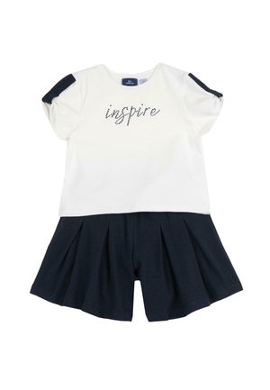 Biała bawełniana koszulka z krótkim rękawem, z napisem "inspire" wykonanym z czarnych kryształków, w połączeniu z granatowymi spódniczkami w plisy. Miękka faktura, swobodny fason.