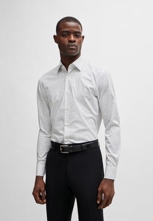 Chemise gris clair avec un petit motif subtil, col boutonné et manches longues ; assortie à un pantalon noir et une ceinture noire.