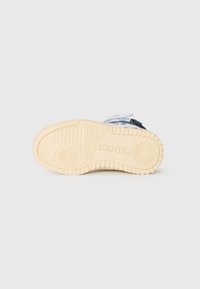 Schoenzool in beige rubber met textuurpatronen en branding. Ontworpen voor grip met diepe loop en ronde accenten voor tractie.