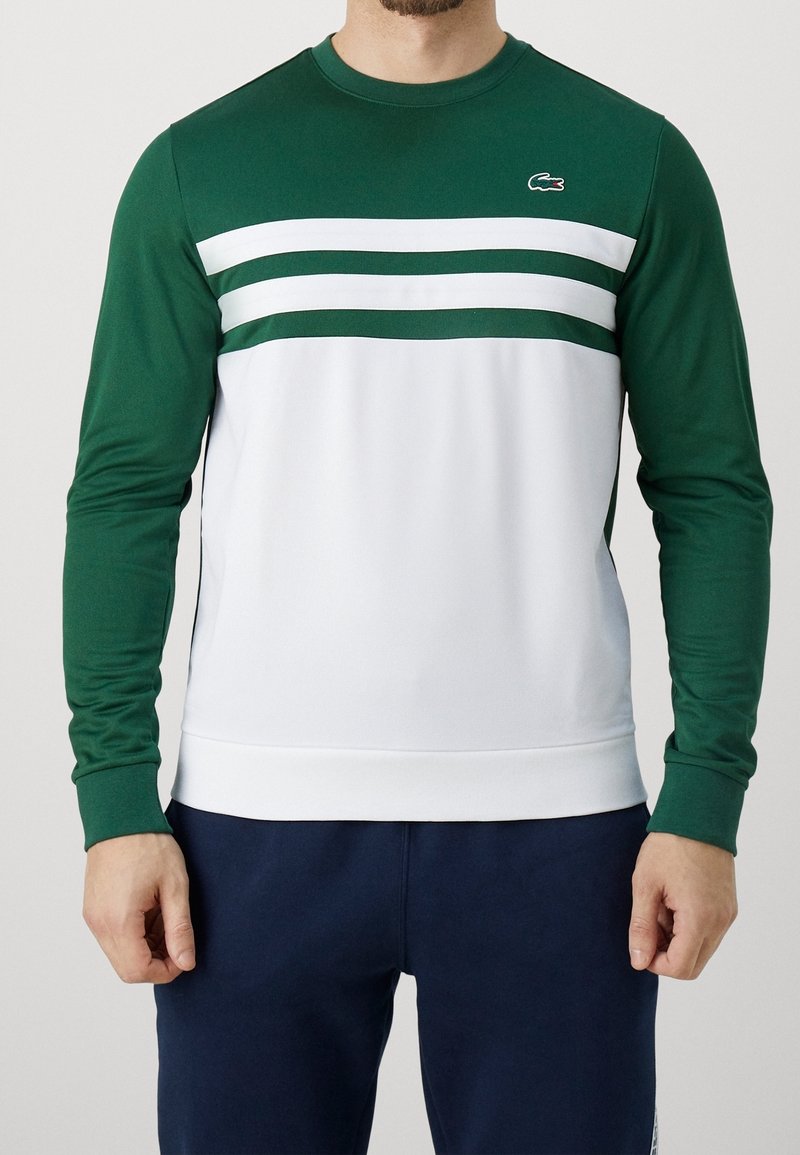 Grön långärmad sweatshirt med vita horisontella ränder, med rund halsringning och ribbstickade ärmslut, tillverkad av ett slätt, elastiskt tyg.