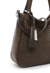Sac à main en cuir marron avec motif tissé, deux poignées, bandoulière amovible et pampille décorative avec étiquette métallique.