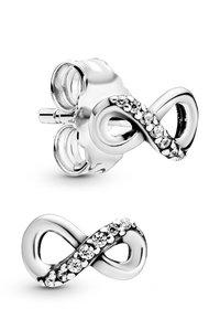 Strieborné náušnice v tvare nekonečna so hladkým dizajnom a kryštálovými akcentmi pozdĺž stredu. Zapínanie na klapku. Lesklý povrch.