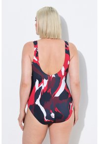 Yksiosainen uimapuku, jossa on monivärinen abstrakti kuvio punaisella, valkoisella ja laivastonsinisellä; siinä on ohuet olkaimet ja matala selkädusain.