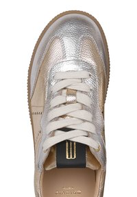 Metallisch silberne und goldene Sneakers mit weißen Schnürsenkeln, die eine strukturierte Oberfläche, kontrastierende Nähte und ein schwarzes Akzentlabel aufweisen.