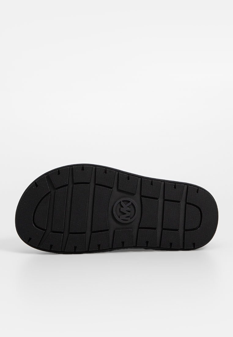 Svart skosula med strukturerat gummimaterial och ett mönster för bra grepp. Cirkulär logotyp i mitten av sulan. Platt och bred design.