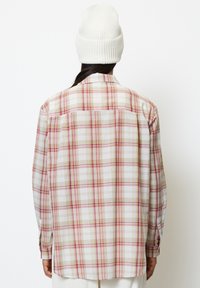 Long-sleeve plaid shirt in beige, white, and pink, featuring a button-down collar, straight hem, and back yoke detail. Cotton blend fabric.
