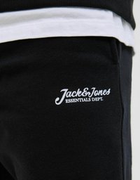 Czarne bawełniane dresy o miękkiej teksturze z białym nadrukowanym logo "Jack & Jones ESSENTIALS DEPT." na lewym udzie.