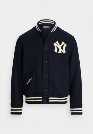 Navy wool varsity jacket with white striped ribbed collar and cuffs, featuring an embroidered NY logo and a signature on the front.