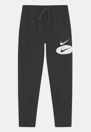 Pantaloni del sudore neri con vita regolabile, tasche laterali e un grande logo Nike bianco sulla parte bassa della gamba destra. Tessuto morbido in mistura di cotone.