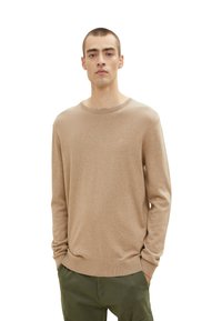 Beżowy sweter z dzianiny z okrągłym dekoltem, długimi rękawami oraz ściągaczami przy mankietach i dolnej krawędzi, wykonany z miękkiego, lekkiego materiału.