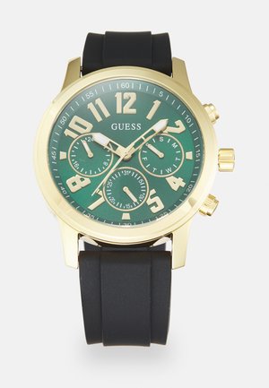 Goldfarbener Chronograph mit grünem Ziffernblatt, schwarzem Gummiband, großen arabischen Ziffern und drei Hilfszifferblättern für zusätzliche Funktionen.
