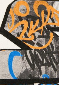 T-shirt grafico caratterizzato da una combinazione di testo in stile graffiti arancione, blu e nero su uno sfondo grigio e bianco testurizzato.