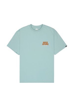 T-shirt bleu clair à manches courtes et col rond avec petit logo orange « Quiksilver Since 1969 » sur la poitrine gauche et étiquette logo noire sur la manche gauche.