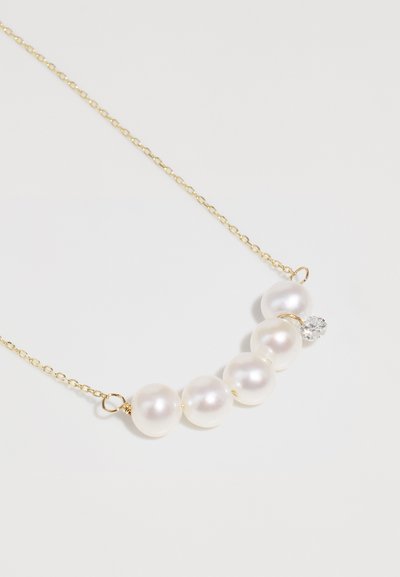 Χρυσή αλυσίδα λαιμού με πέντε λαμπερές λευκές πέρλες και κρύσταλλο, απαλή υφή με απλό, κομψό σχέδιο.