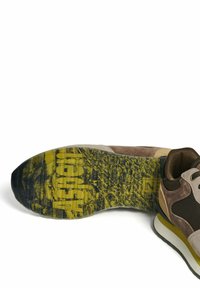 Zapato deportivo con parte superior de ante marrón, gris y tostado; suela de goma amarilla con un patrón que muestra "Aspen"; suela gruesa y texturizada.