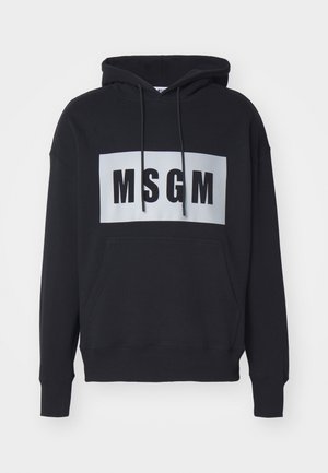 Svart hettegenser med frontlomme, med en hvit rektangulær logo som har "MSGM" i fete svarte bokstaver. Laget av bomull, avslappet passform.