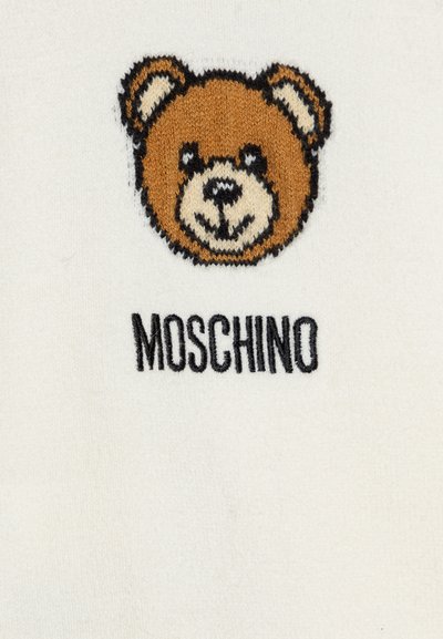 Tessuto bianco con un orso ricamato in marrone e beige, con contorni neri, accanto alla parola "MOSCHINO" in testo nero.