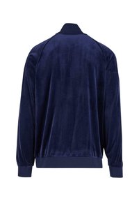 Chaqueta de terciopelo azul marino con cuello alto, mangas largas, puños acanalados y una textura suave. La vista trasera muestra un diseño simple y sólido.