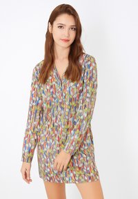 Vestido de manga larga multicolorido con un patrón de hojas sobre un fondo claro, con un corte relajado y un escote en forma de V.