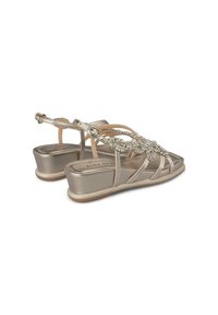 Sandali con zeppa in metallo taupe con finitura testurizzata. Presentano decorazioni con strass e una fascia alla caviglia regolabile.