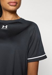 Black athletic shirt made of moisture-wicking fabric. Features a crew neck, short sleeves with white accents, and an Under Armour logo.