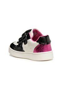 Sneaker bianco e nero con finitura lucida e dettagli in glitter rosa, dotato di cinturini in velcro e suola bianca testurizzata.