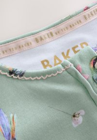 Šviesiai žalias medvilninis marškinėliai su gėlių raštu, banguotu apykakle ir auksinėmis raidėmis "BAKER by TED BAKER" viduje. Minkštas paviršius.