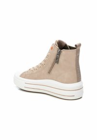 Zapatillas altas beige con parte superior texturizada, suela de plataforma blanca, cremallera lateral y parte delantera con cordones. Presenta un detalle de logo naranja en la lengua.