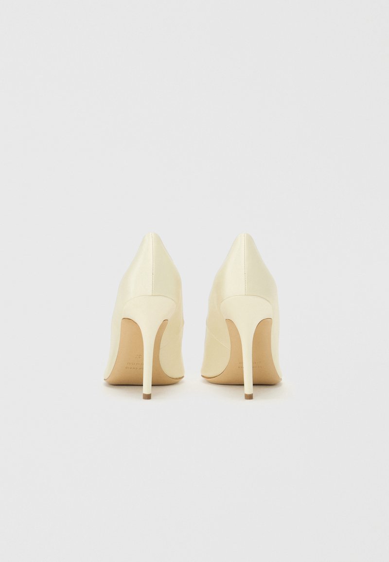 Cremfarbene High Heels mit spitzem Zeh und Stiletto-Absatz. Glatte Lederoberfläche, minimalistisches Design mit einer subtilen Kurve am Absatz.