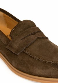 Bruine suède instappers met een gestikte accentband, ronde neus en een lichte rubberen zool. Kenmerken zijn de gladde textuur en het strakke ontwerp.